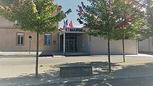 place avec parking et arbres devant l'entée de la mairie de Meauzac